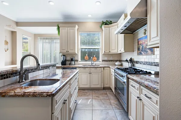 a kitchen with a sink stove top oven and cabinets
