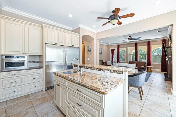a large kitchen with kitchen island a large counter space appliances and living room view
