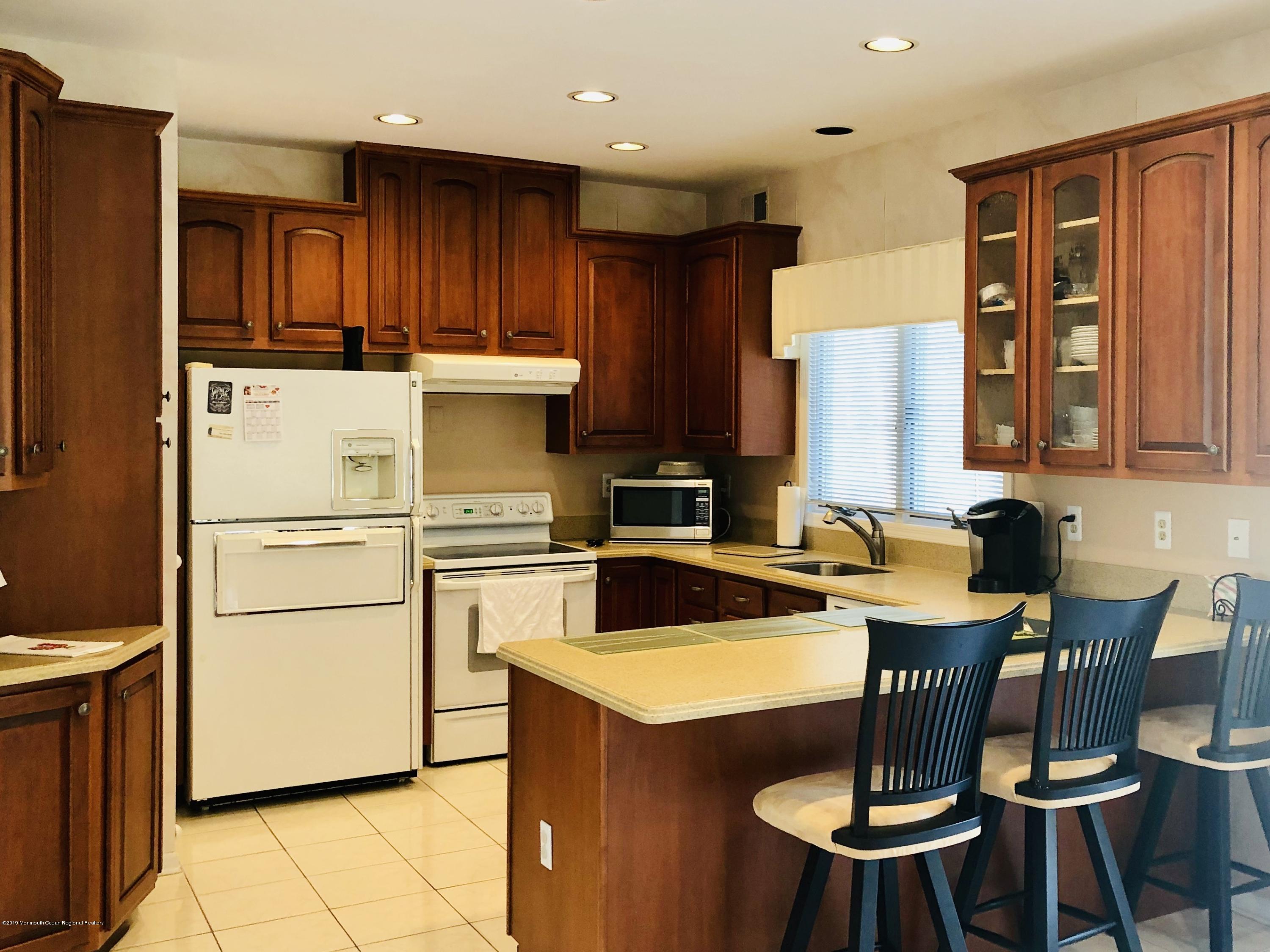 259 Nottingham Road Morganville, NJ 07751 - Photo 9 of 28 a kitchen with a stove a refrigerator and wooden cabinets