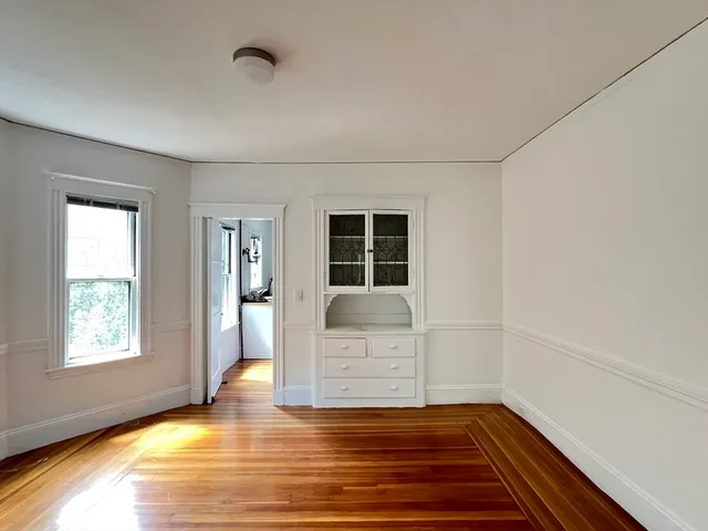 a view of a livingroom with wooden floor and a window