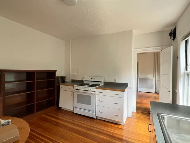 a kitchen with a stove and a wooden floors