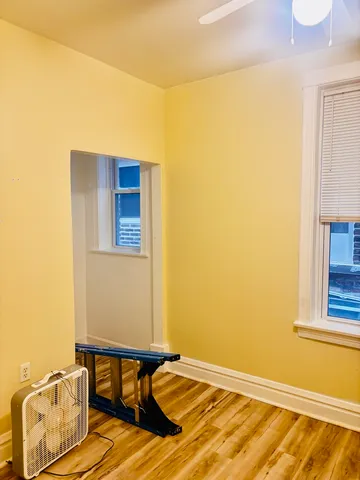 a view of a room with wooden floor and a window