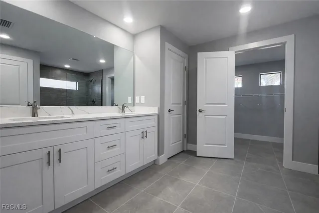 a spacious bathroom with a mirror sink and shower