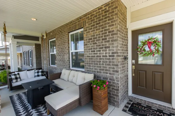 a living room with furniture a rug a fireplace and a window