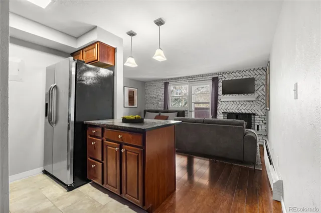 a kitchen with stainless steel appliances granite countertop a refrigerator a stove and a wooden floors