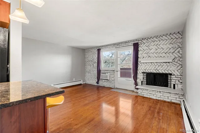a view of an empty room with a fireplace and a window