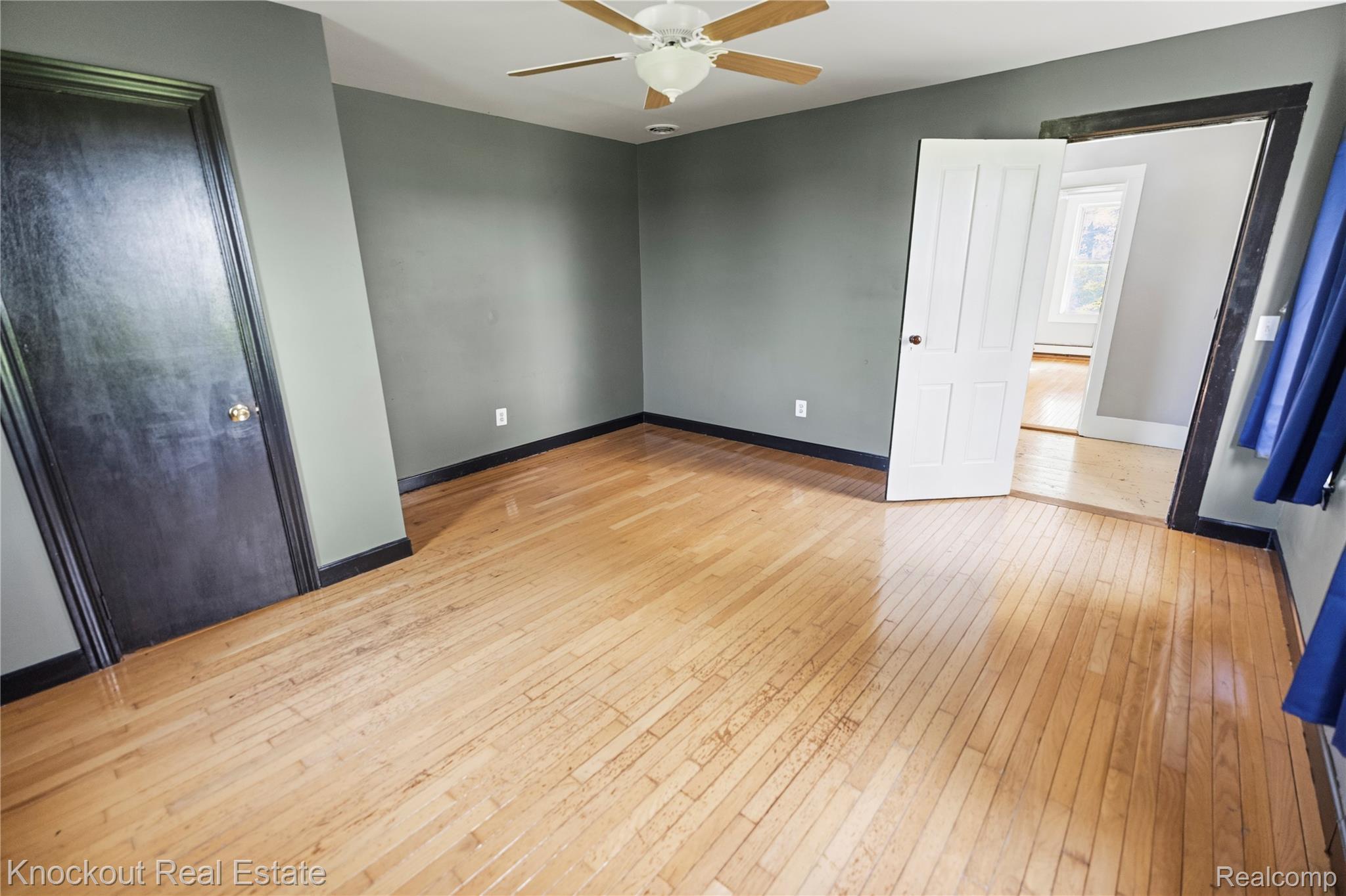 5750 Maple Road Frankenmuth, MI 48734 - Photo 23 of 60 Hardwood flooring throughout, ceiling fan with integrated lighting, dark accent trim, and a white paneled door