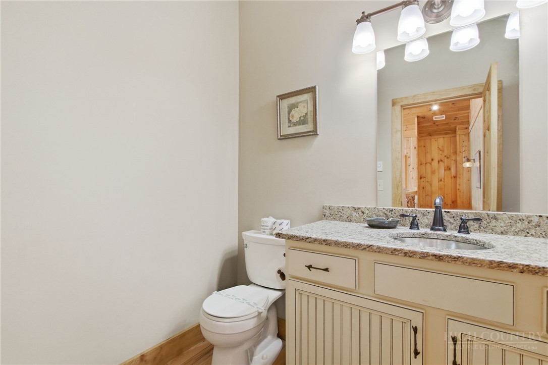 2081 Blackberry Road Boone, NC 28607 - Photo 25 of 45 a bathroom with a granite countertop sink mirror vanity and toilet