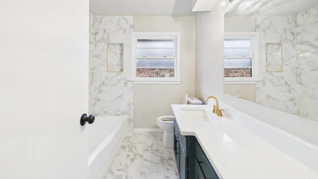 a bathroom with a tub sink and mirror