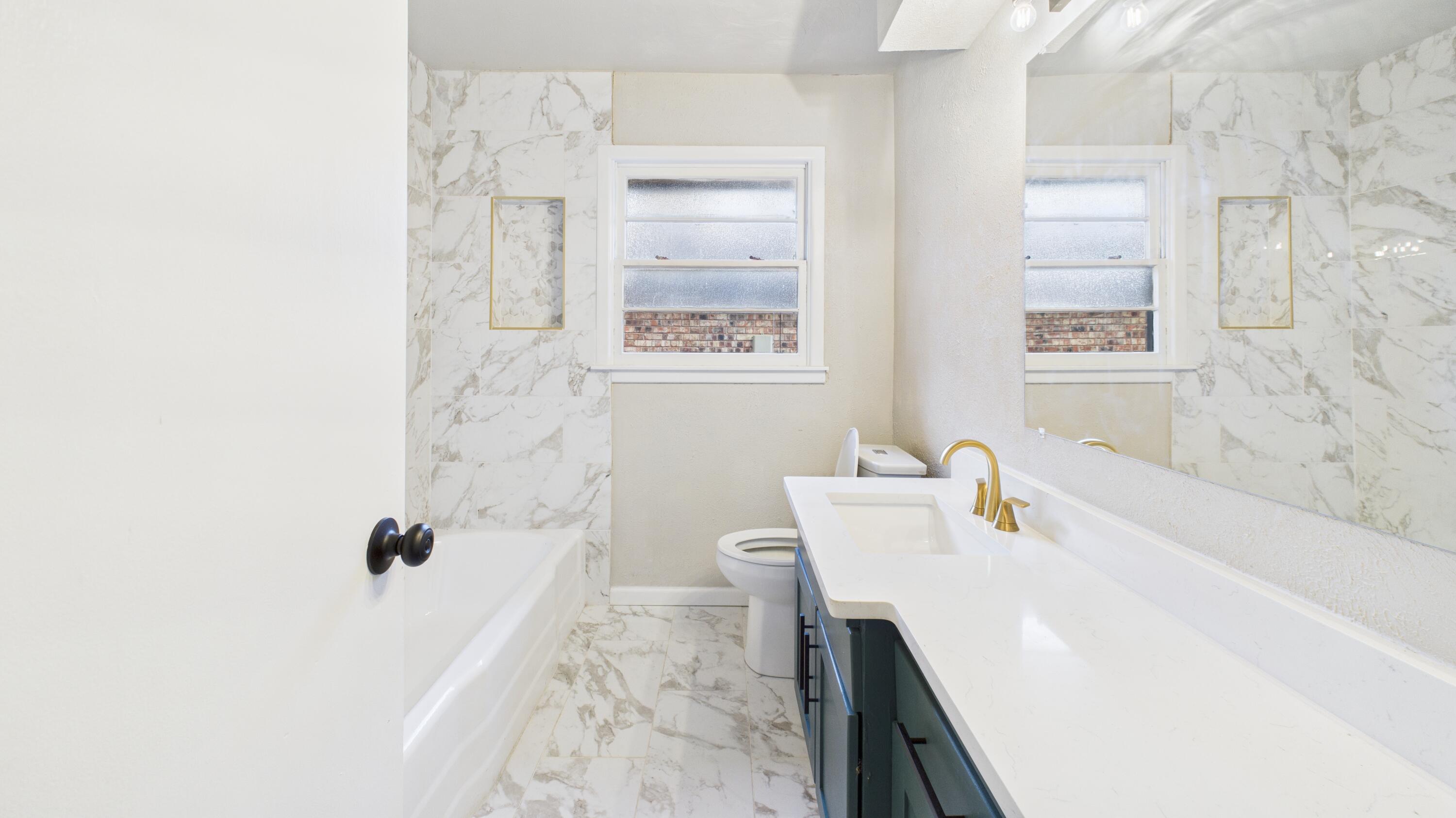 2013 69th Street Lubbock, TX 79412 - Photo 17 of 19 a bathroom with a tub sink and mirror