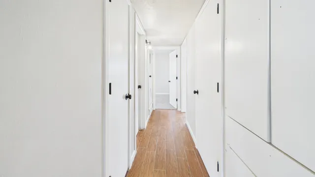 a view of a hallway with wooden floor