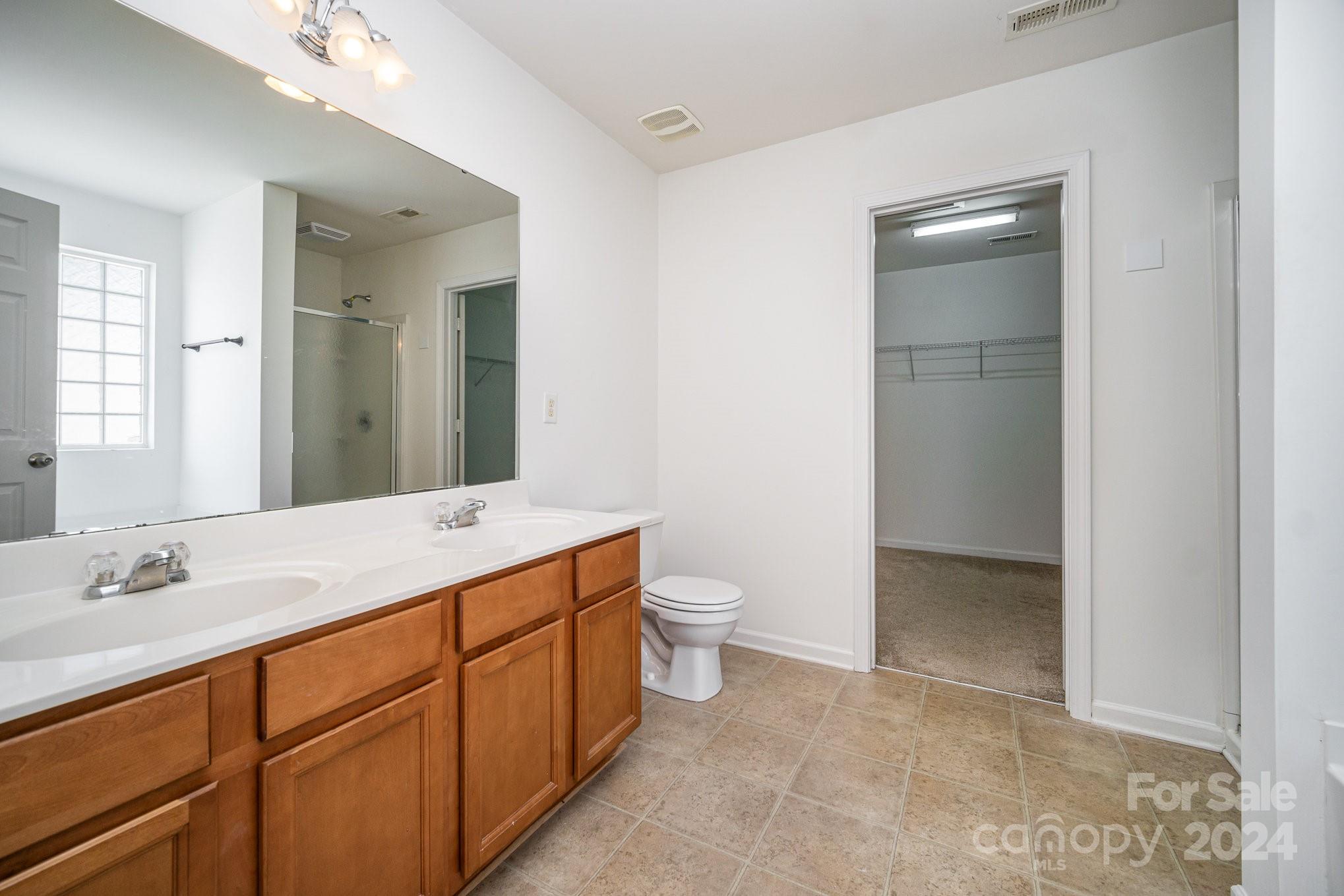 1007 Yellow Bee Road Indian Trail, NC 28079 - Photo 12 of 21 a spacious bathroom with a granite countertop sink toilet and shower