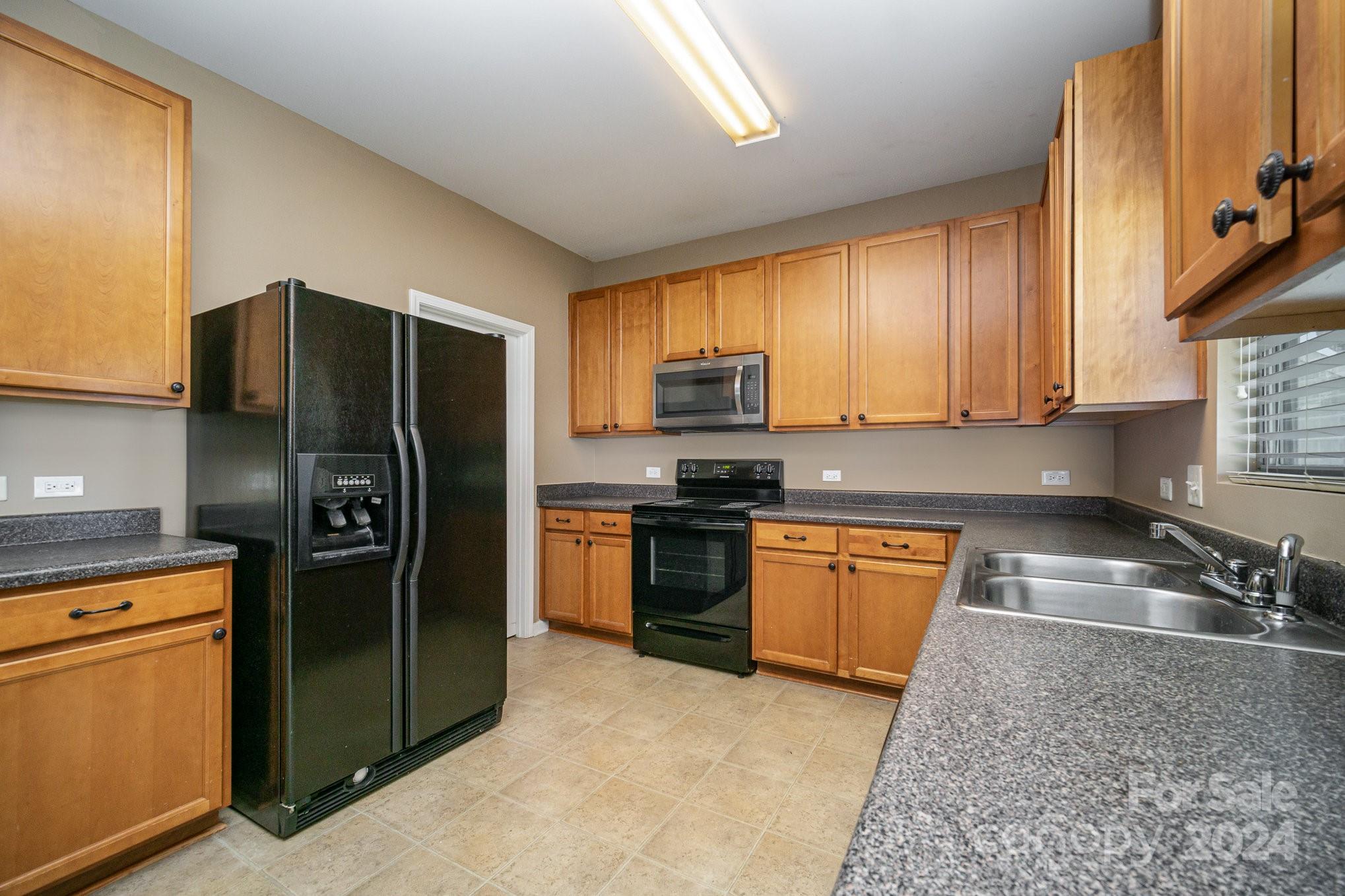 1007 Yellow Bee Road Indian Trail, NC 28079 - Photo 7 of 21 a kitchen with stainless steel appliances granite countertop a refrigerator stove and sink