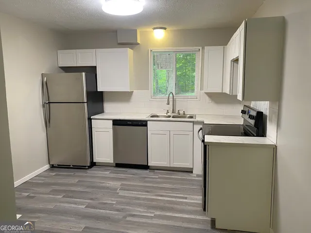 a kitchen with a sink stove and refrigerator