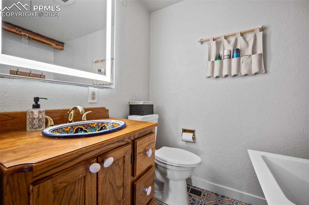 925 High Road Manitou Springs, CO 80829 - Photo 12 of 20 a bathroom with a toilet a sink and a mirror