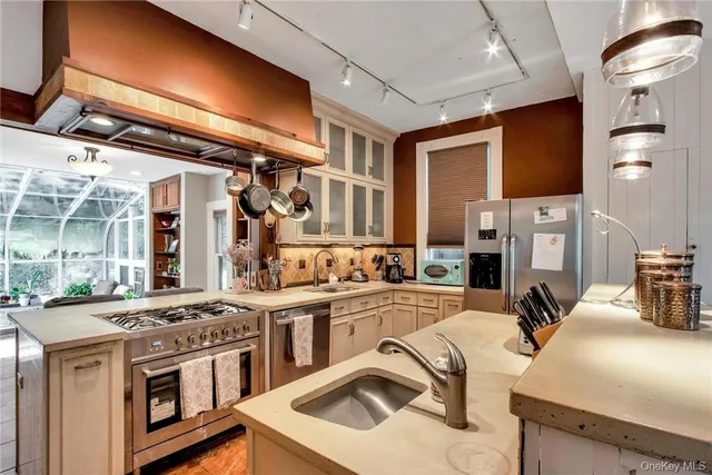 a kitchen with stainless steel appliances granite countertop a sink stove and refrigerator