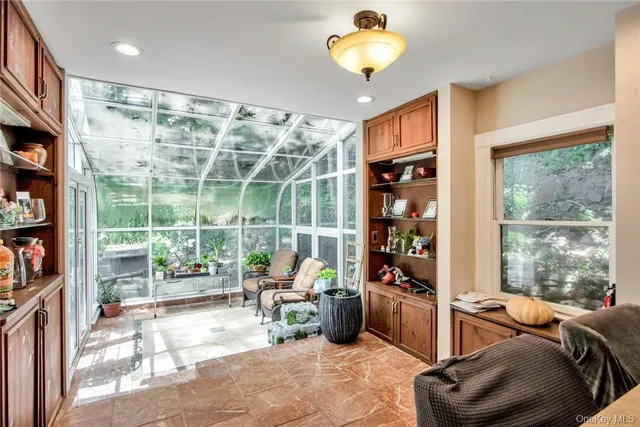 a view of a chairs and table in a room and a window