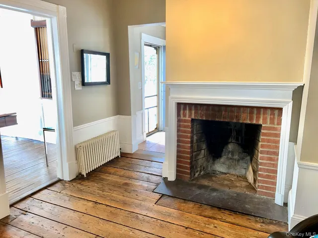 a view of a livingroom with wooden floor and a fireplace