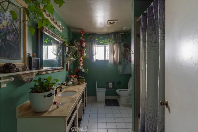 a room with a potted plant wooden floor and a toilet