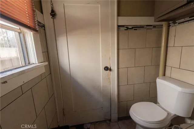 a white toilet sitting next to a shower