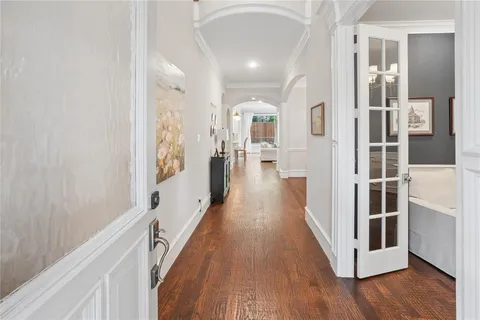 a view of a hallway with wooden floor and staircase
