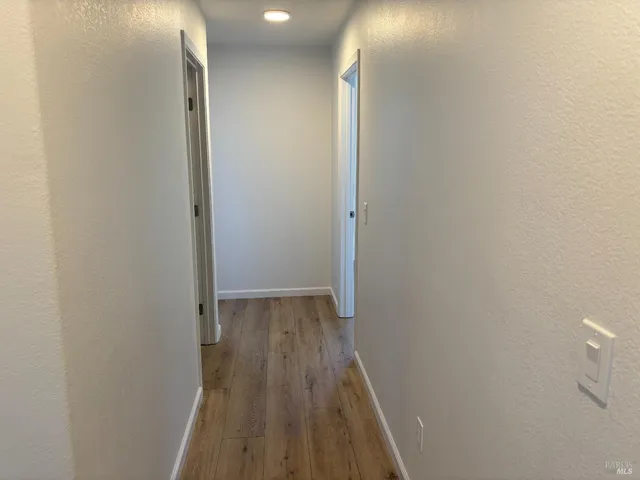 a view of a room with wooden floor and fan