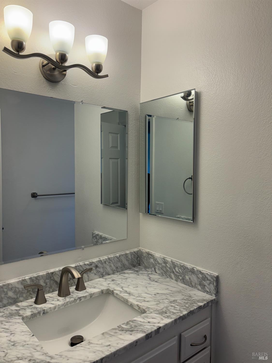 1776 Meda Avenue Santa Rosa, CA 95404 - Photo 25 of 28 a bathroom with a granite countertop sink and a mirror