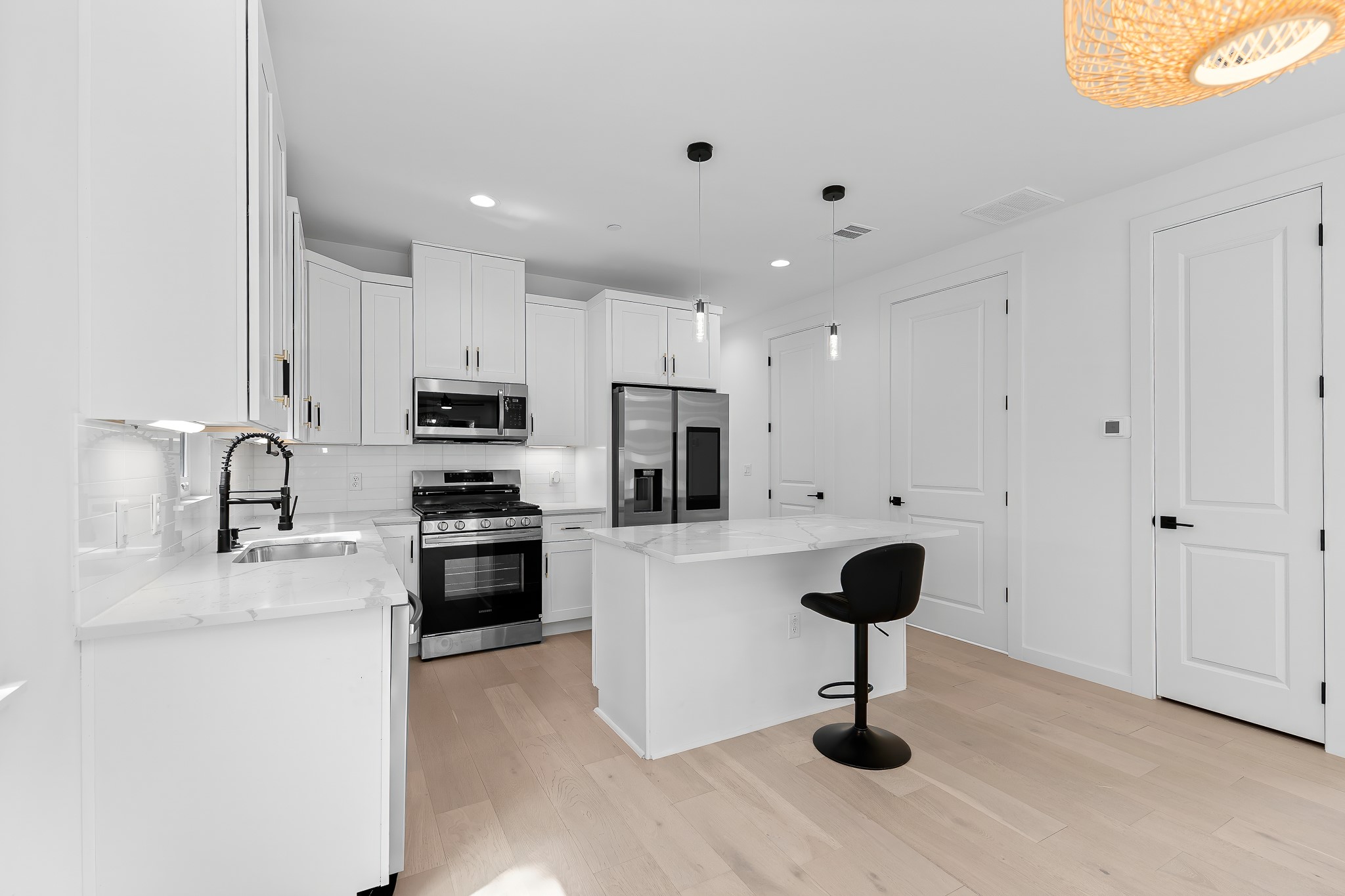 5305 Ledesma Road, Unit 4 Austin, TX 78721 - Photo 1 of 40 A well-appointed kitchen features stainless steel appliances, a center island with bar seating, and light-toned hardwood flooring.