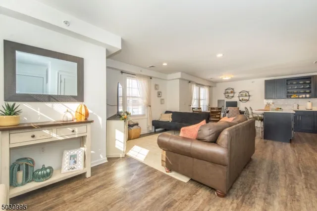 a living room with furniture wooden floor and kitchen view