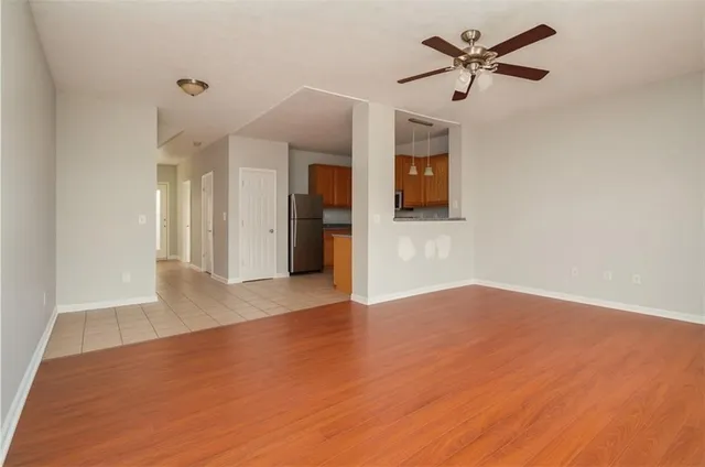 a view of a livingroom with a ceiling fan wooden floor and a ceiling fan