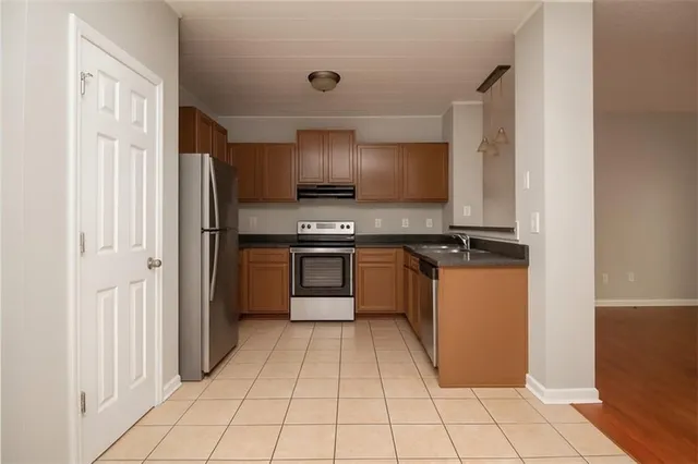 a kitchen with stainless steel appliances granite countertop a refrigerator and a stove