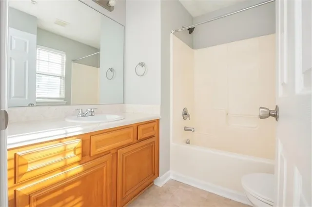 a bathroom with a granite countertop sink a mirror bathtub and shower