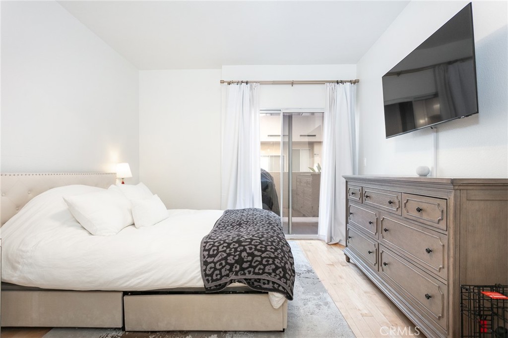 19350 Sherman Way, Unit 124 Reseda, CA 91335 - Photo 14 of 26 a bedroom with a bed and a flat tv screen