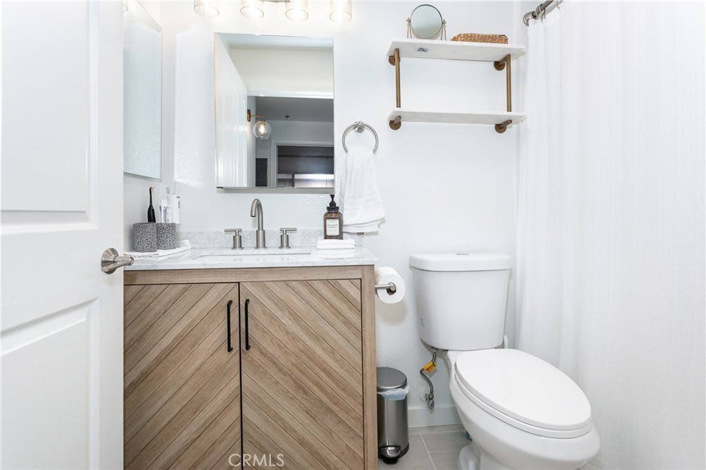 19350 Sherman Way, Unit 124 Reseda, CA 91335 - Photo 18 of 26 a bathroom with a sink a toilet and mirror