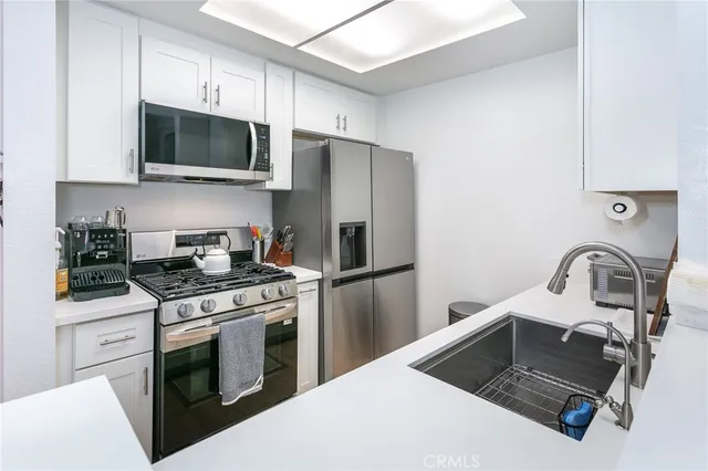 a kitchen with a stove a sink and a refrigerator
