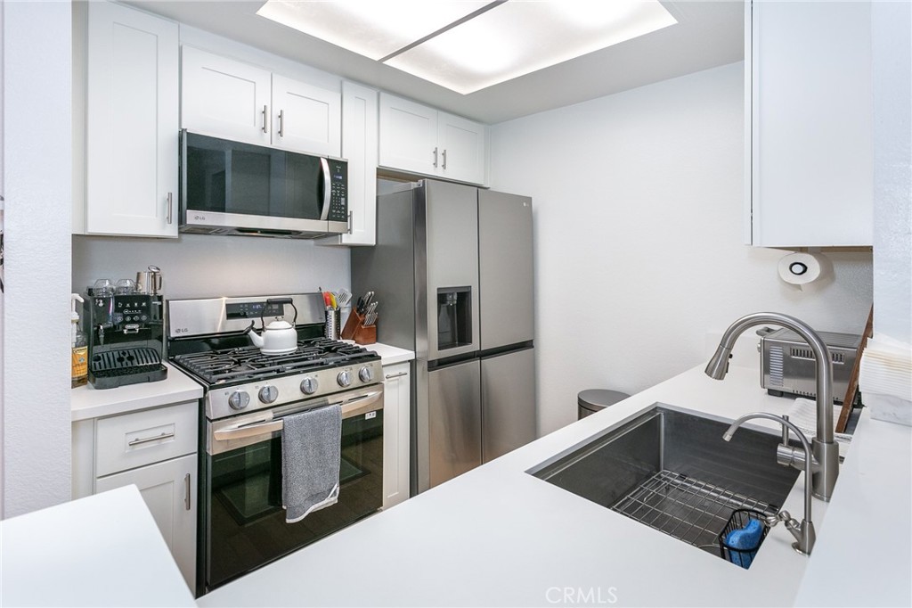 19350 Sherman Way, Unit 124 Reseda, CA 91335 - Photo 5 of 26 a kitchen with a stove a sink and a refrigerator