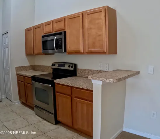 a kitchen with stainless steel appliances granite countertop a sink and a microwave