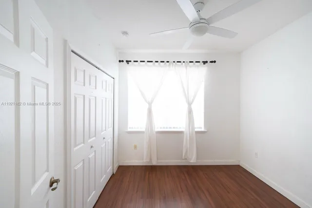 a view of a house with a yard and palm trees