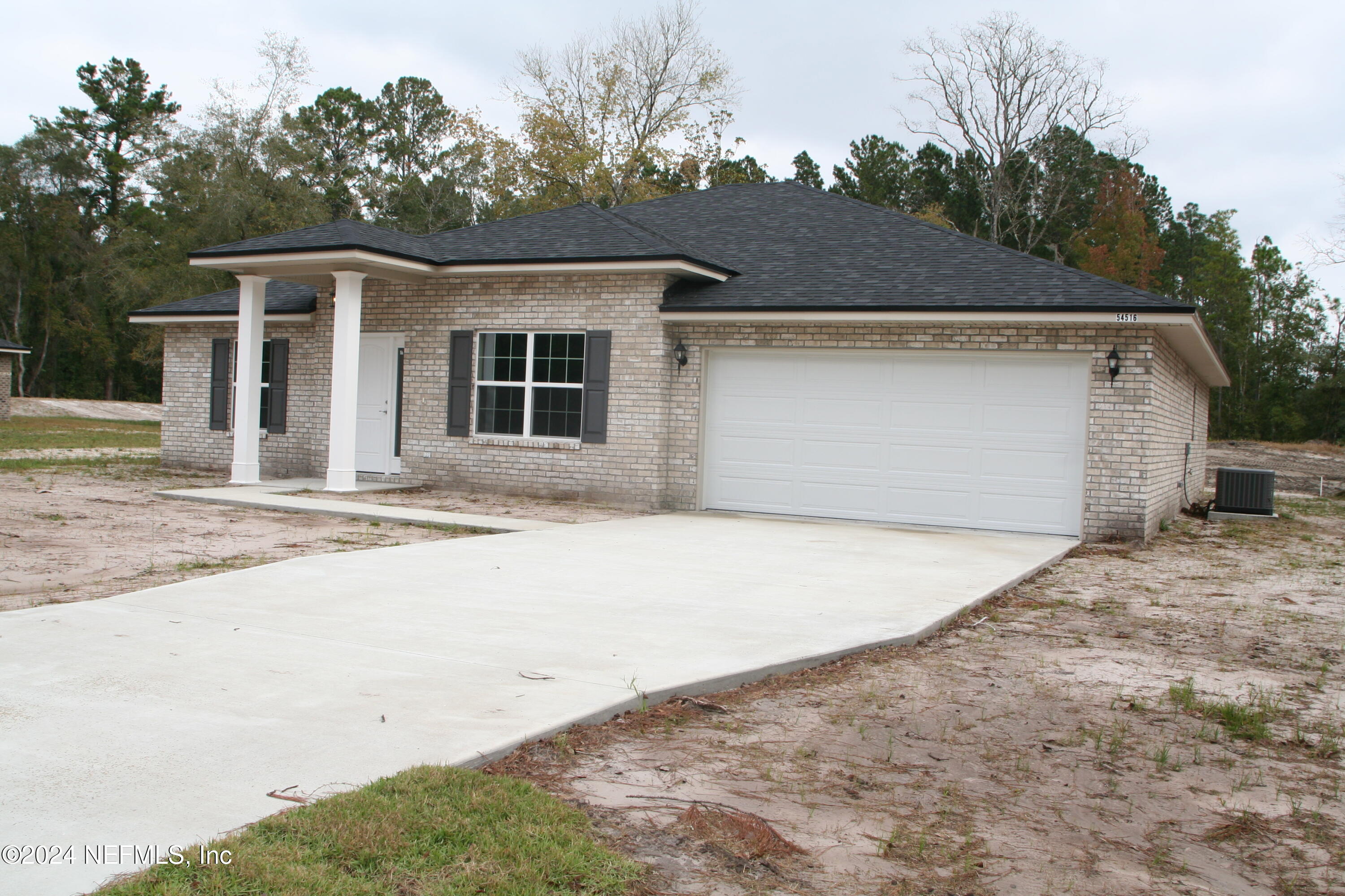 54516 Church Road Callahan, FL 32011 - Photo 2 of 39 a front view of a house with a yard and garage