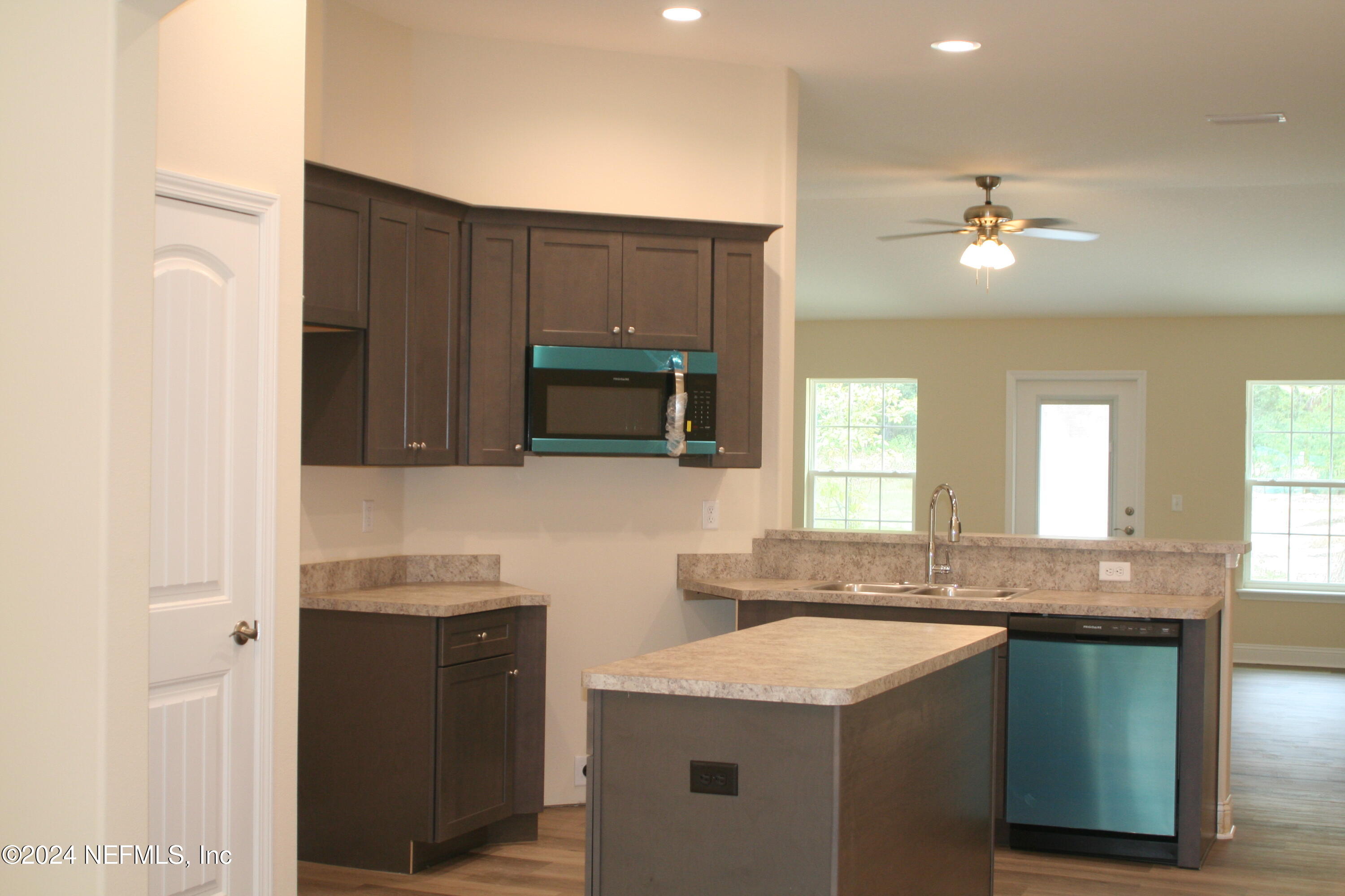 54516 Church Road Callahan, FL 32011 - Photo 3 of 39 a kitchen with stainless steel appliances granite countertop a sink and a microwave