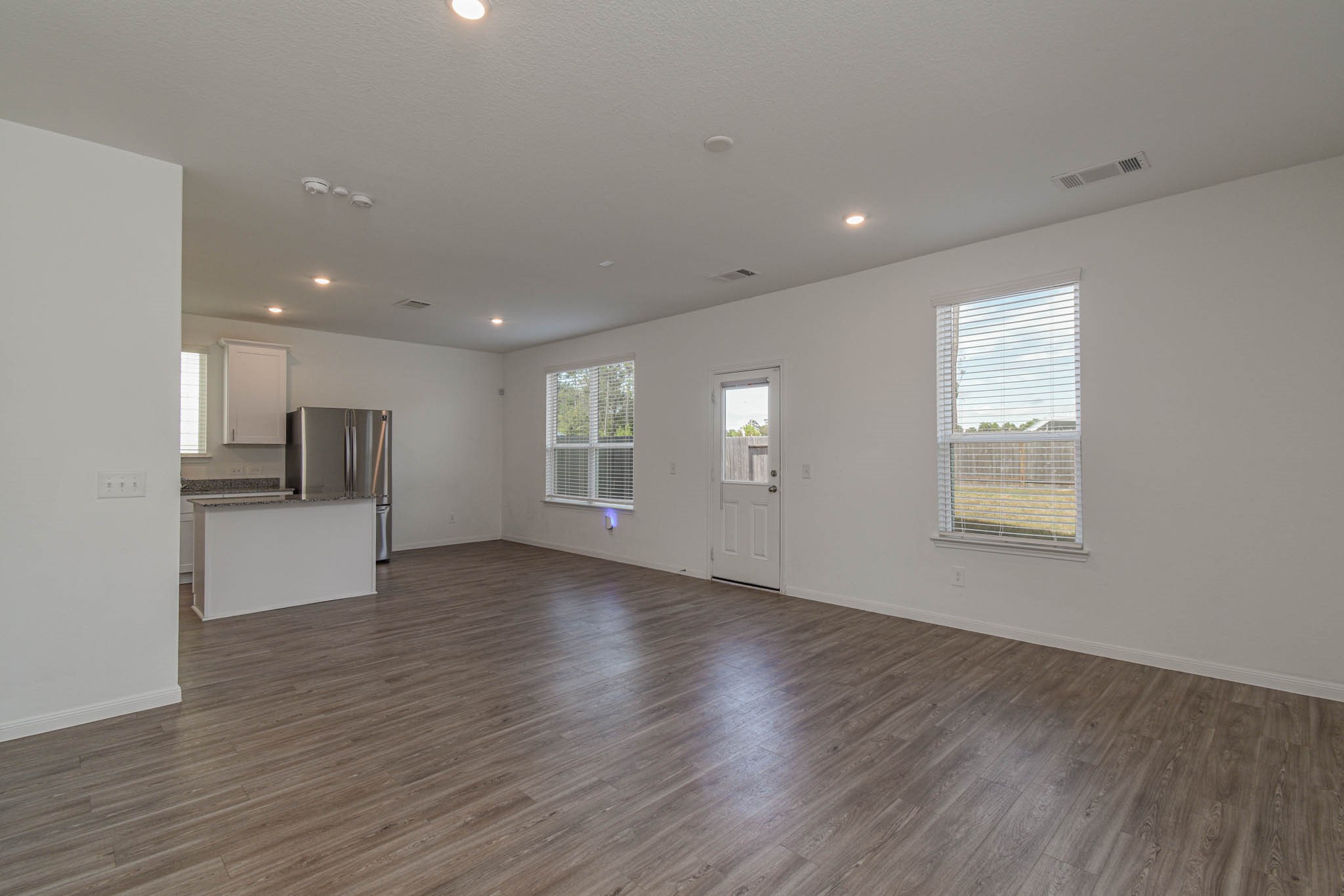 5727 Finely Run Street Spring, TX 77373 - Photo 8 of 26 a view of an empty room with wooden floor and a window