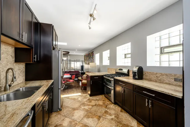 a kitchen with stainless steel appliances granite countertop a sink dishwasher stove and refrigerator