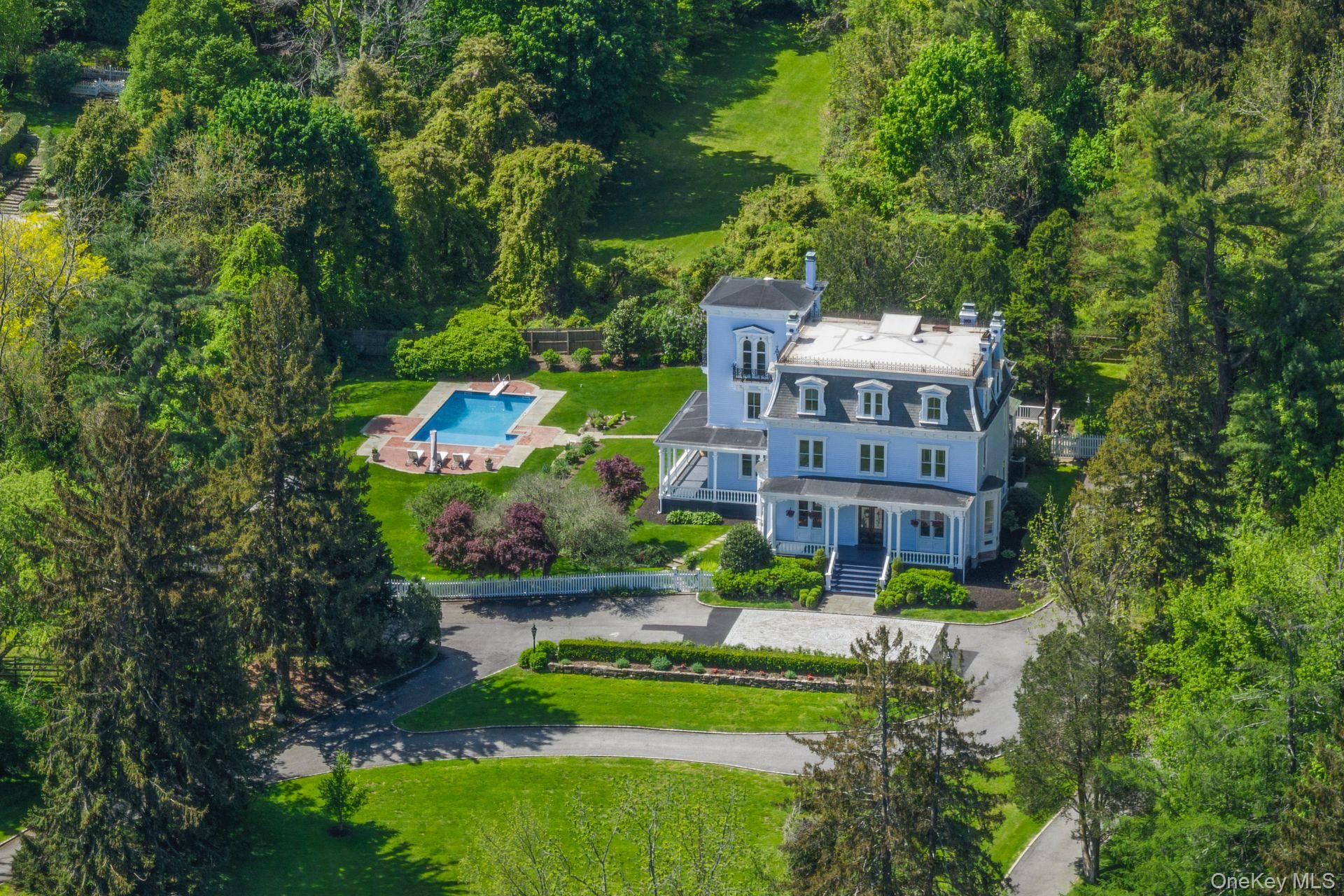 a view of a big yard with plants and large trees
