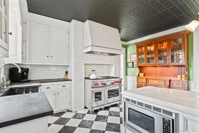 a kitchen with stainless steel appliances a stove a sink and a microwave