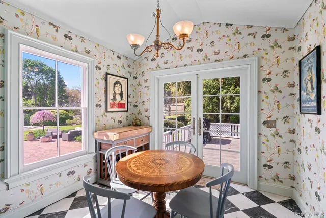 a dining room with furniture a chandelier and wooden floor