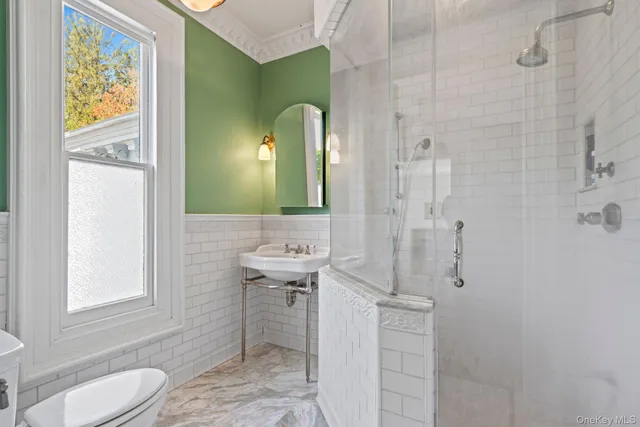 a bathroom with a sink a toilet and shower