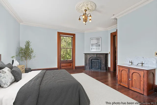 a bedroom with a bed and a fireplace with mirror