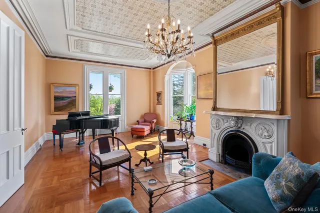 a living room with furniture a chandelier and a fireplace
