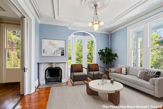 a living room with furniture a chandelier and a fireplace
