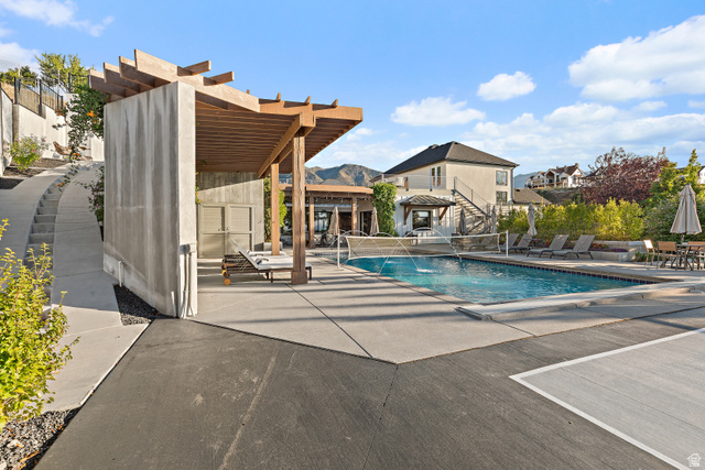 912 North Loafer Canyon Road Elk Ridge, UT 84651 - Photo 57 of 98 Outdoor swimming pool with integrated water features, expansive concrete decking, a substantial wood pergola, and a separate concrete structure with privacy screens